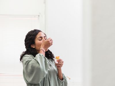 BIPOC woman taking a pill