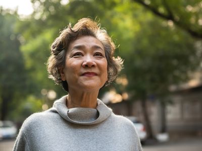 Portrait of cheerful senior woman relaxing outdoor, standing on the road in the city 