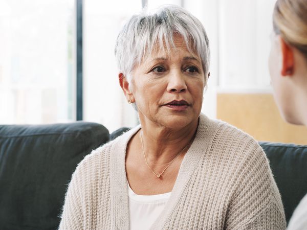 Shot of a nurse consoling a senior woman in a nursing home