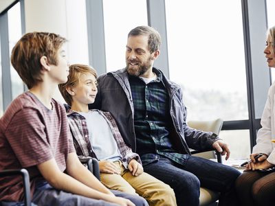 Boy with parent and sibling talking to a doctor