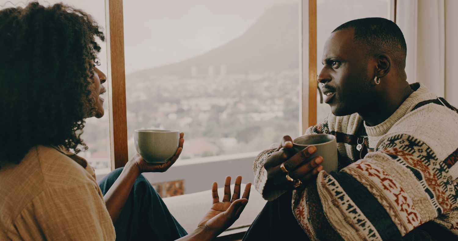 Shot of a young couple having coffee and a chat at home