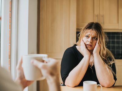 person sitting at a table looking sad and fearful