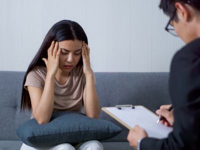 Sad woman with depression having consultation with psychiatrist in hospital mental health service center