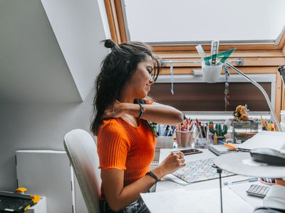 person with neck pain at their desk