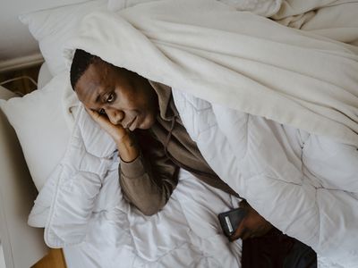 BIPOC man sad in bed