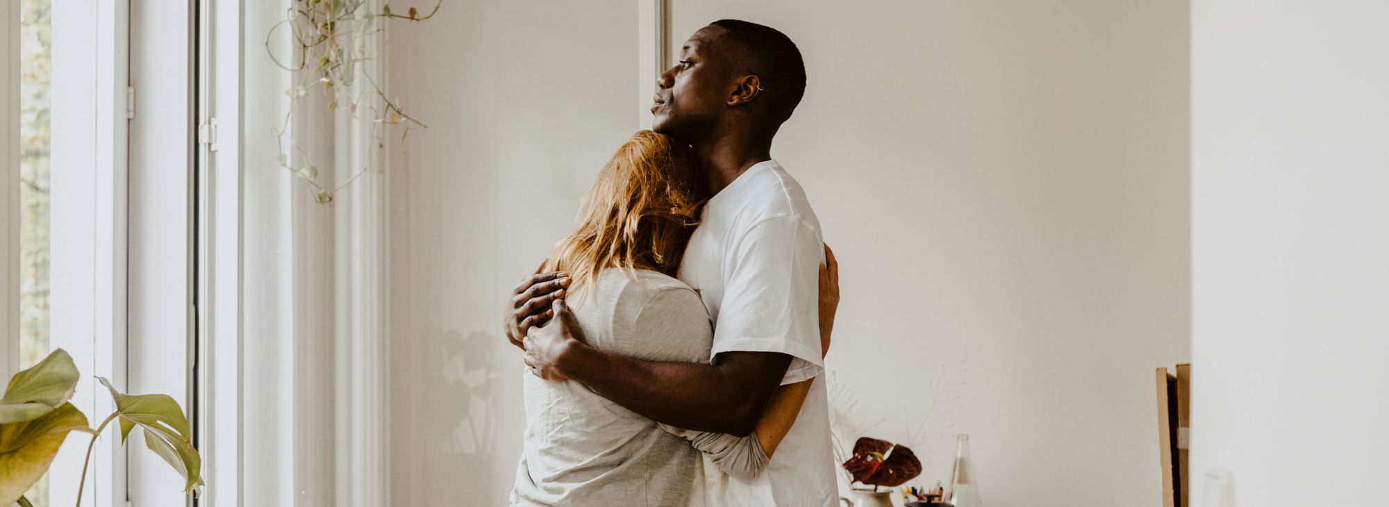 man and woman embracing while standing in living room