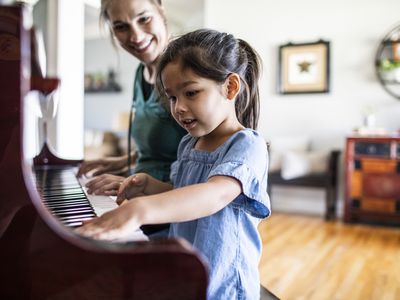 Mother and daughter playing piano