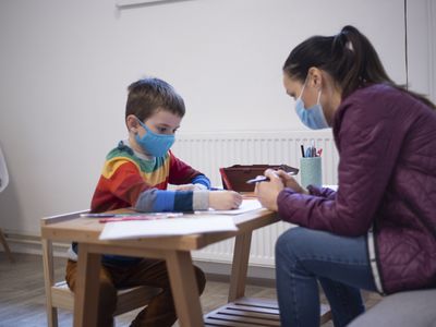 Six years old boy working with a psychologist at the psychotherapy session.