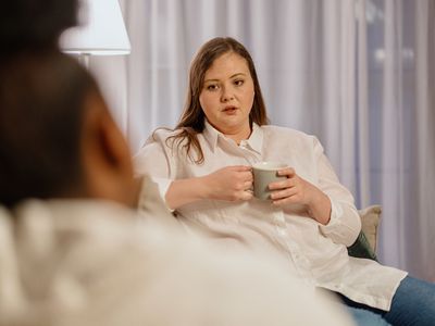 person talking to their therapist while holding a cup of coffee