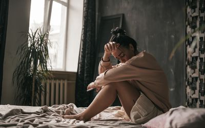 woman sad on bed