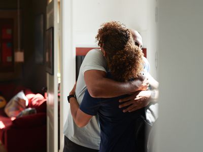 Caregiver embracing man at home