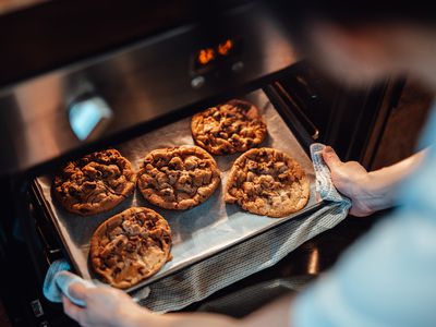 pulling cookies out of the oven