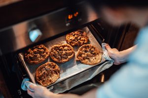 pulling cookies out of the oven