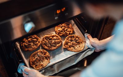 pulling cookies out of the oven