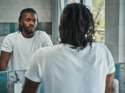 Calm man concentrated on examining his face in bathroom