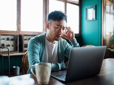 person stressed out while working on their laptop