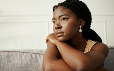 Shot of a young woman looking depressed at home