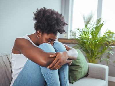 woman at home feeling ashamed and unhappy