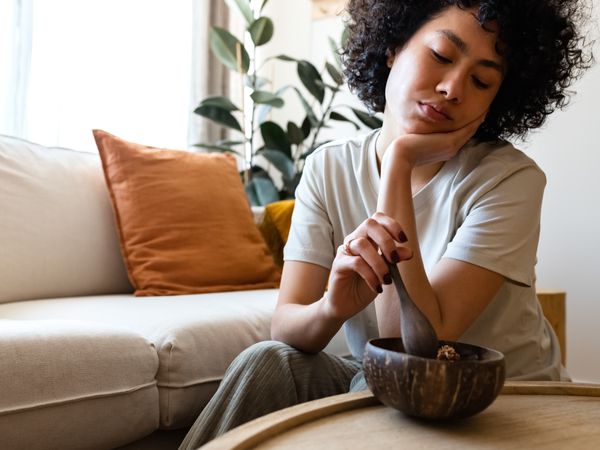 Young woman eating breakfast feeling very bored and unmotivated