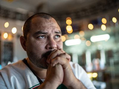 Mid adult man watching a soccer game at bar