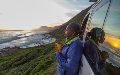 woman looking at a sunset by the sea