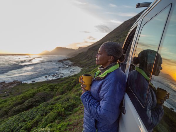 woman looking at a sunset by the sea