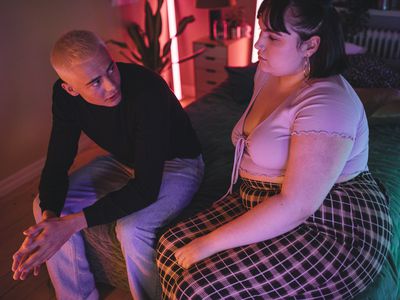 Couple sitting on bed having a conversation