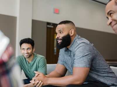 Three men smile during group therapy.