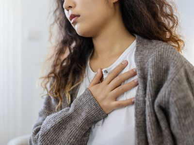 Stressed young woman feeling pain and touching chest suffer from heartache disease at home while having heart attack, infarction