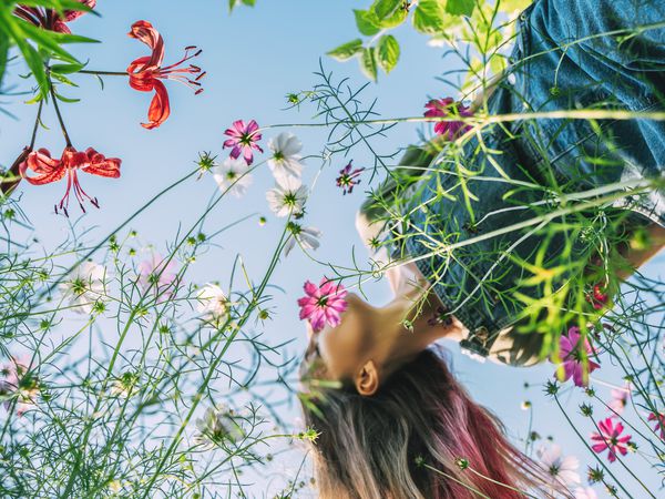 woman with long hair in flowers view from below