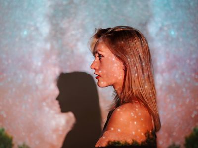 Blond young woman with starry sky projection