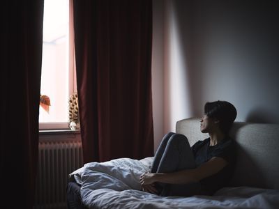 Pensive man sitting on sofa and looking through window