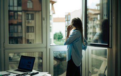 woman standing at the window and talking on the phone