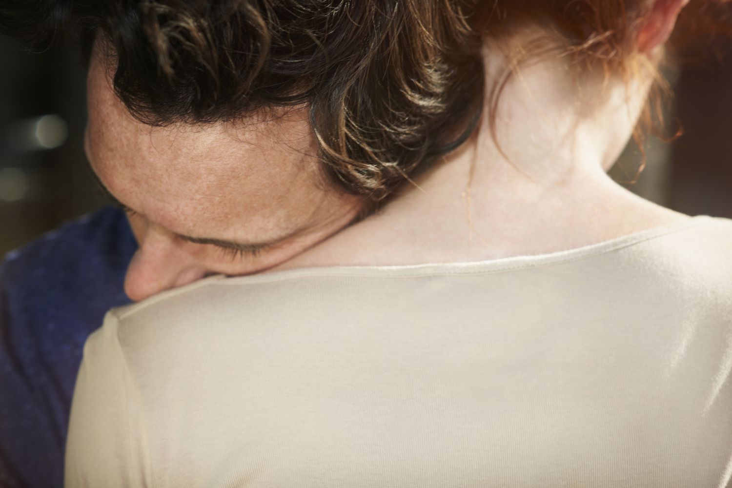 Man resting his head on woman's shoulder