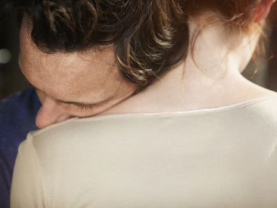 Man resting his head on woman's shoulder