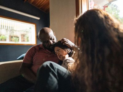 Parents consoling daughter at home