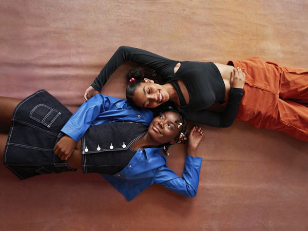 Female friends lying on brown backdrop