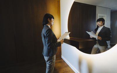 One woman, rehearsing a speech in mirror at home