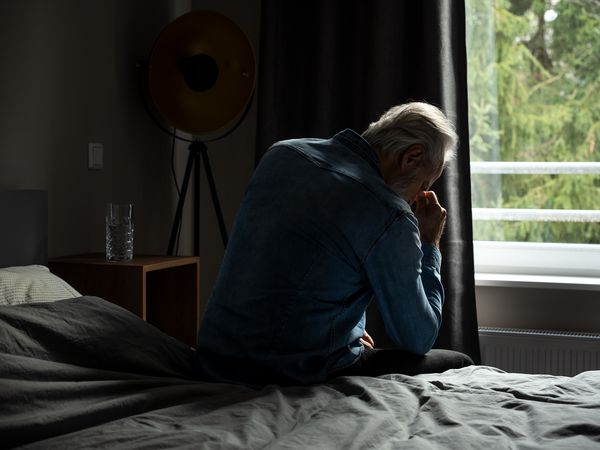 depressed senior man in bedroom