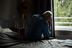 depressed senior man in bedroom