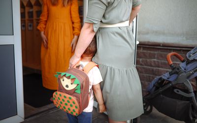 Daughter greets mom with toddler at the door of a house