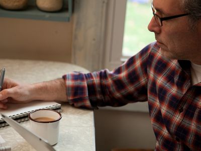 mature man writing at table