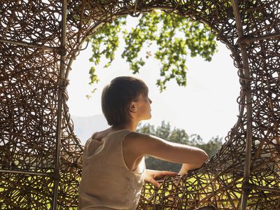 Woman looking out window of nest tree house 