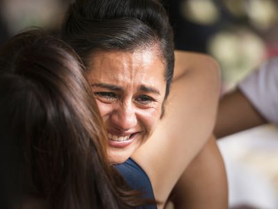 women hugging and crying