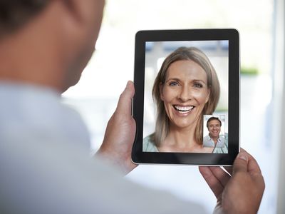 man and woman talking over tablet