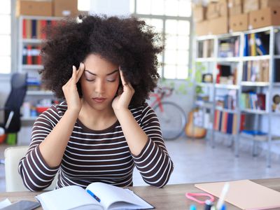 Young woman has a headache at the office