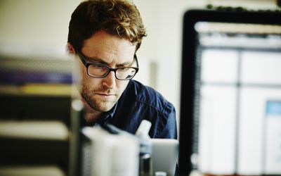 Businessman working on project on laptop in startup office