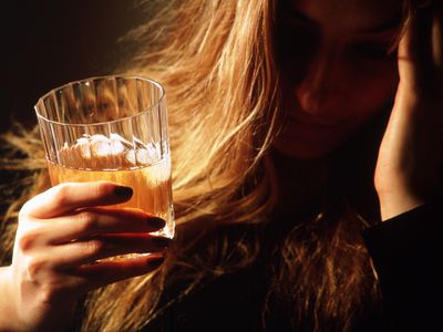 Depressed woman drinking a glass of beer