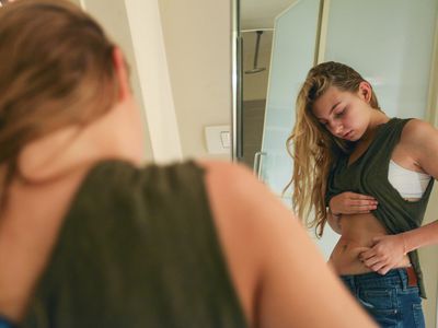 Young Woman pinching her waist