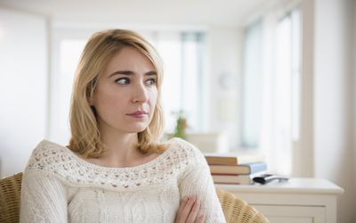 Lonely Caucasian woman sitting in living room